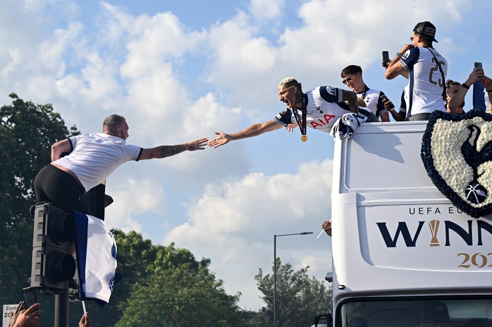 Tottenham Hotspur players celebrating their UEFA Europa League victory in a parade.
