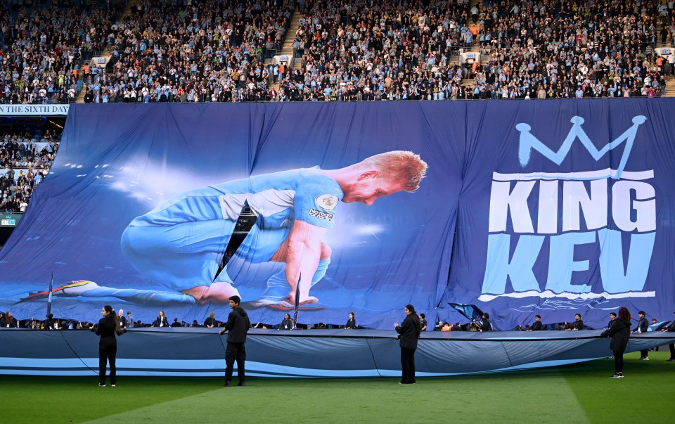 A large banner depicting Kevin De Bruyne with "King Kev" unveiled at a Manchester City match.