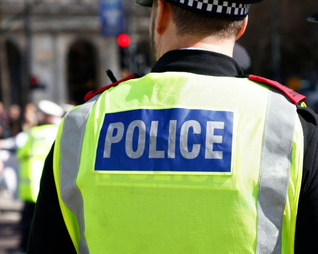 Police officer's back with &quot;POLICE&quot; on vest.