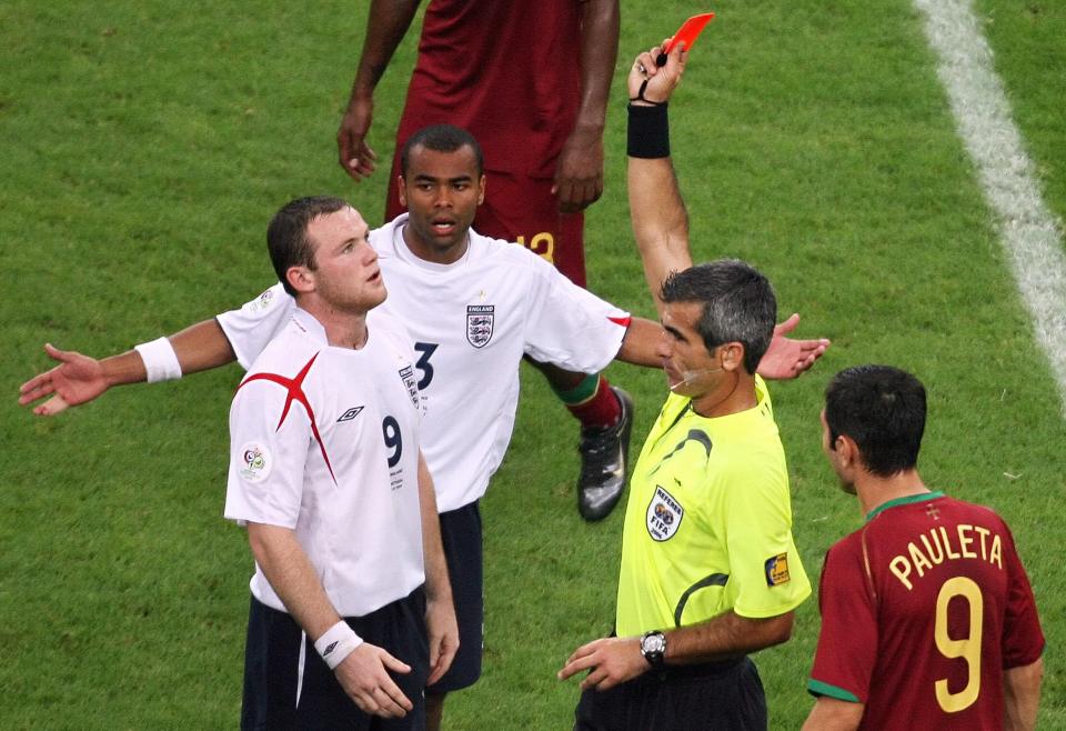Referee showing Wayne Rooney a red card during a soccer match.
