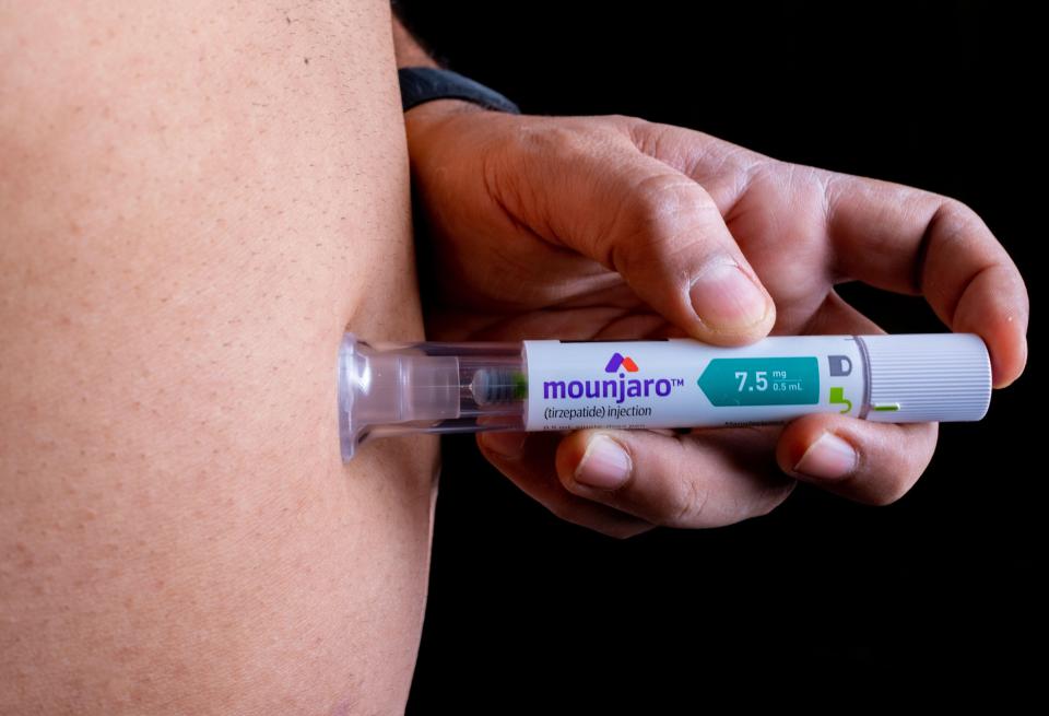 Person injecting Mounjaro.