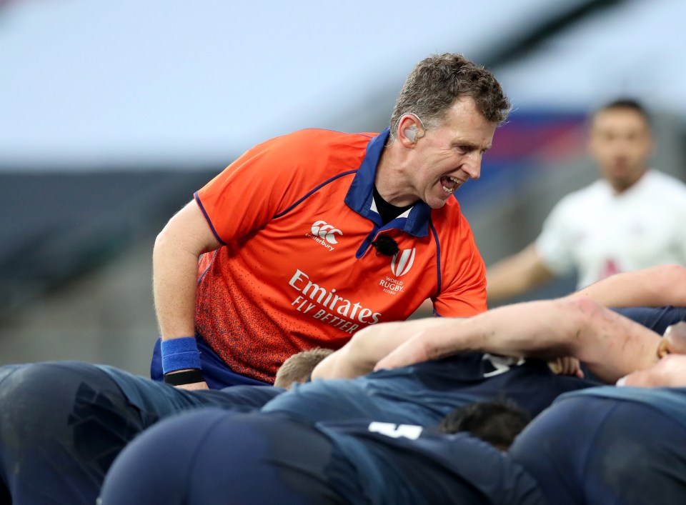 Referee Nigel Owens officiating a rugby scrum.
