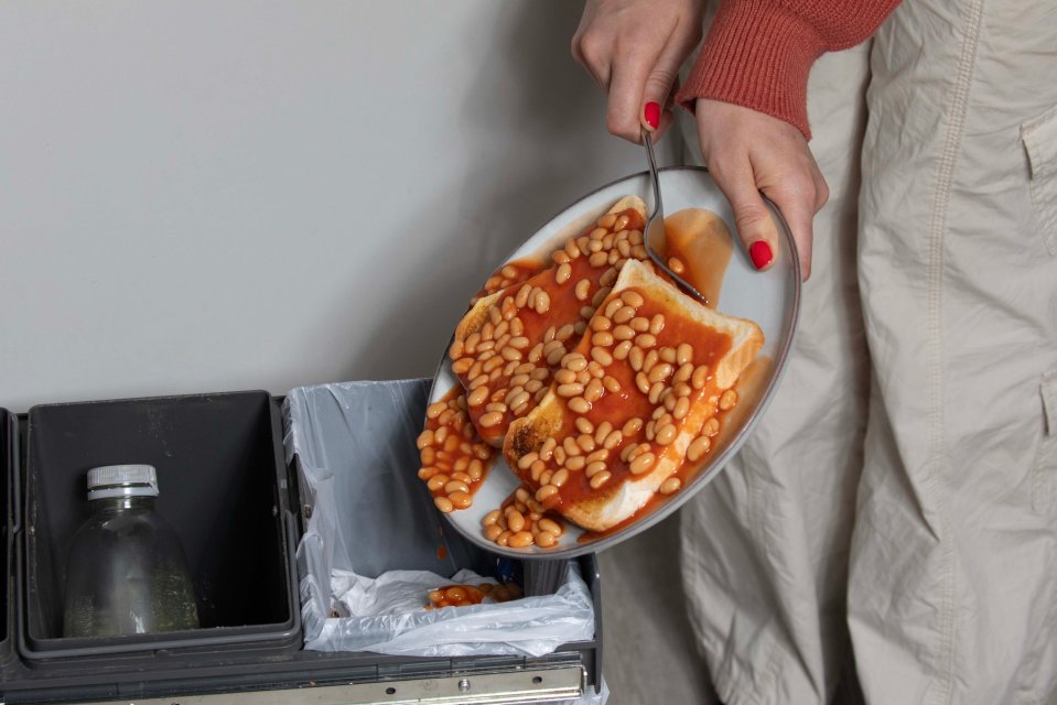 Beans on toast being thrown in the trash.