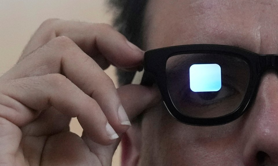Man wearing augmented reality glasses displaying a blue square.
