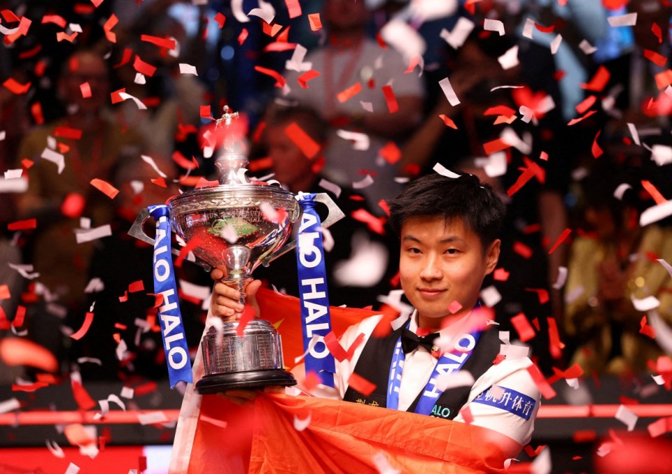 FILE PHOTO: Snooker - World Snooker Championship - The Crucible Theatre, Sheffield, Britain - May 5, 2025 China's Xintong Zhao celebrates with the trophy after winning his final match against Wales' Mark Williams Action Images via Reuters/Andrew Boyers/File Photo