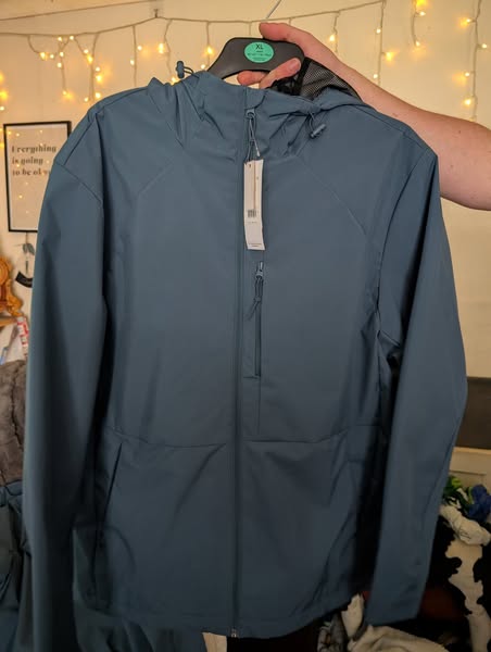 Teal Asda coat on a hanger.