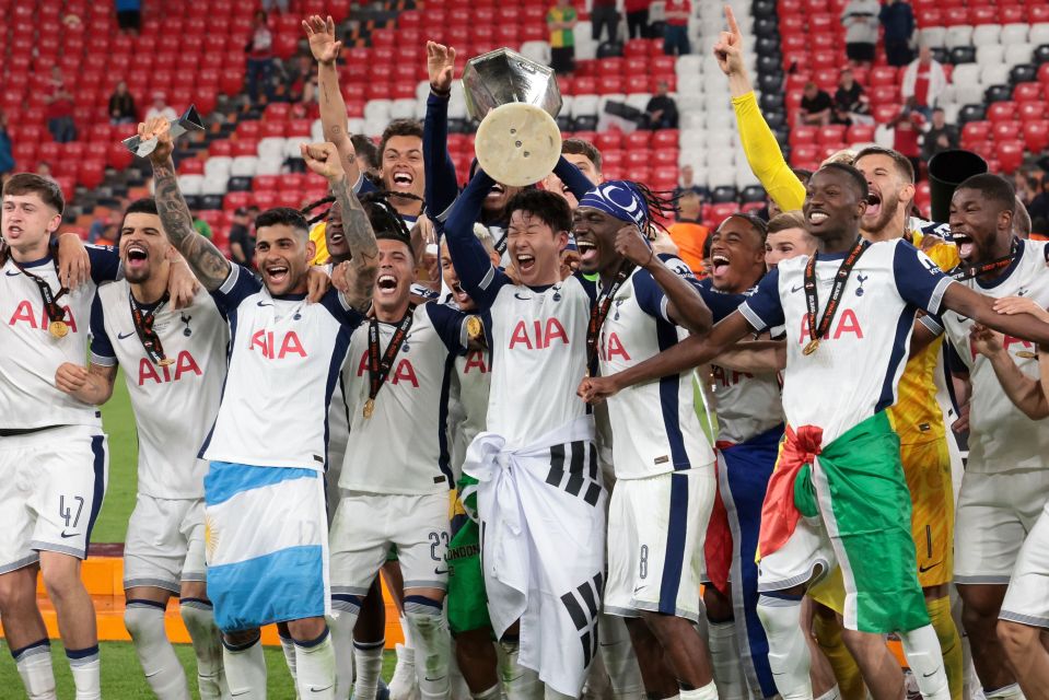 Tottenham Hotspur players celebrating a victory with the trophy.