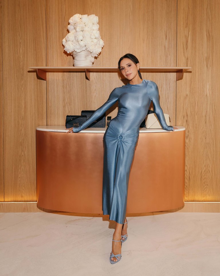 Victoria Beckham in a blue dress at a store event.