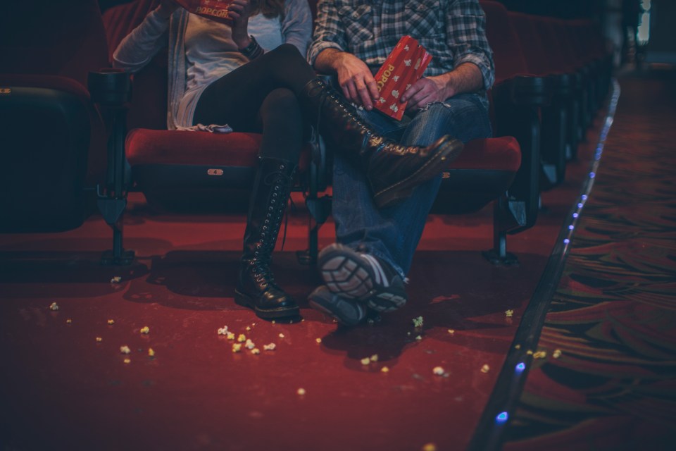 Couple enjoying popcorn at the movie theater.