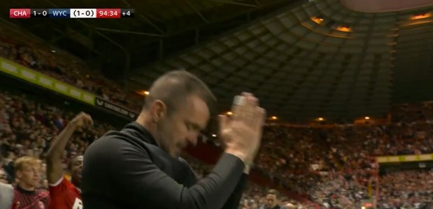 Nathan Jones applauding in a stadium.