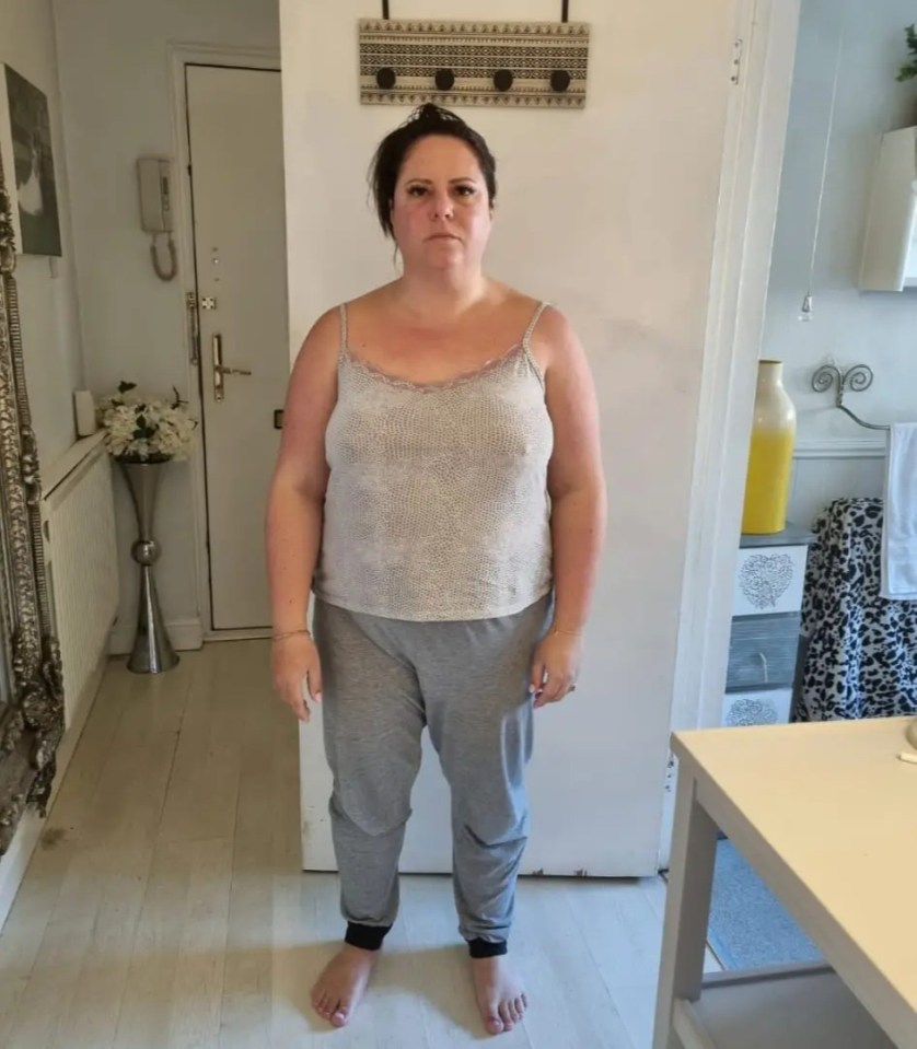 Full-length photo of a woman in a tank top and sweatpants.