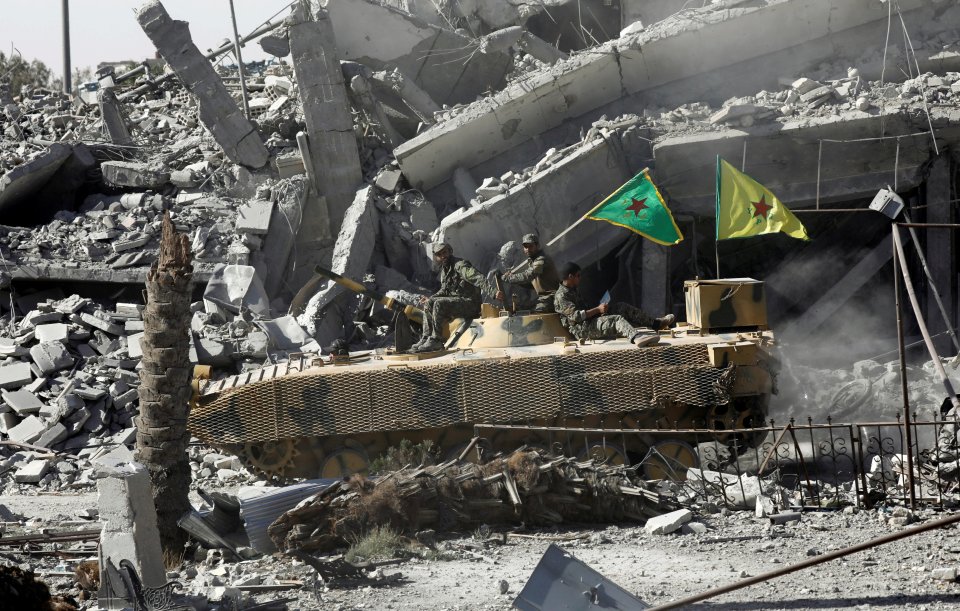Syrian Democratic Forces fighters on an armored vehicle in Raqqa, Syria.