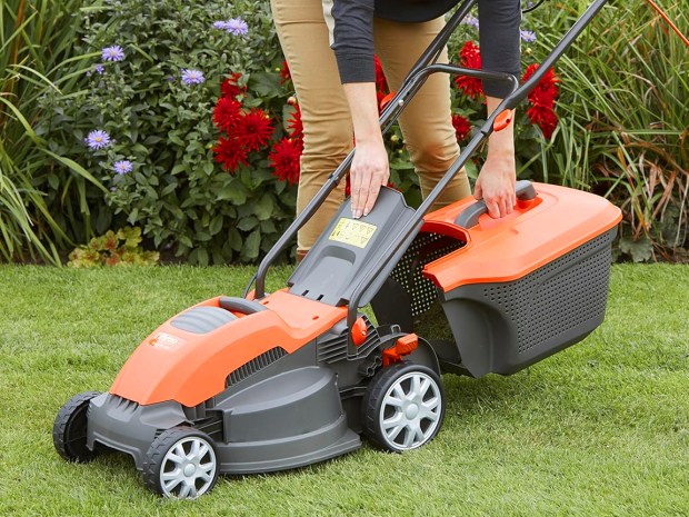 Person emptying the grass catcher of a lawnmower.