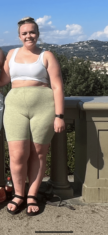 Woman in athletic wear standing outdoors.