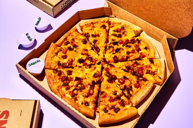 Papa John's pizza in a box with garlic sauce cups.