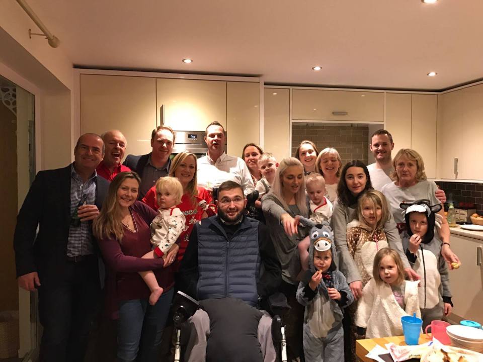 Large group photo of family and friends in a kitchen.