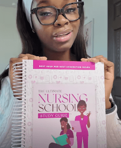 Woman holding a nursing school study guide.
