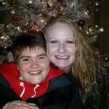 Photo of a woman and a disabled daughter in front of a Christmas tree.