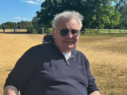 Man in sunglasses sitting outdoors.