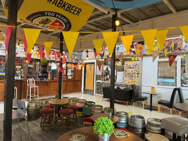 Interior photo of a pub with beer barrels used as tables.