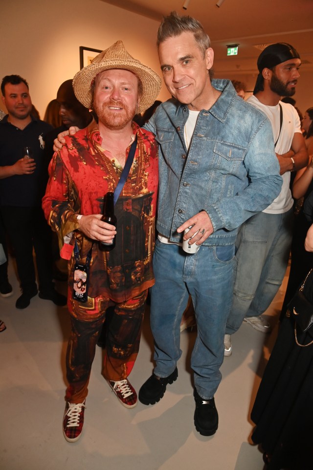 Leigh Francis and Robbie Williams at an art exhibition.