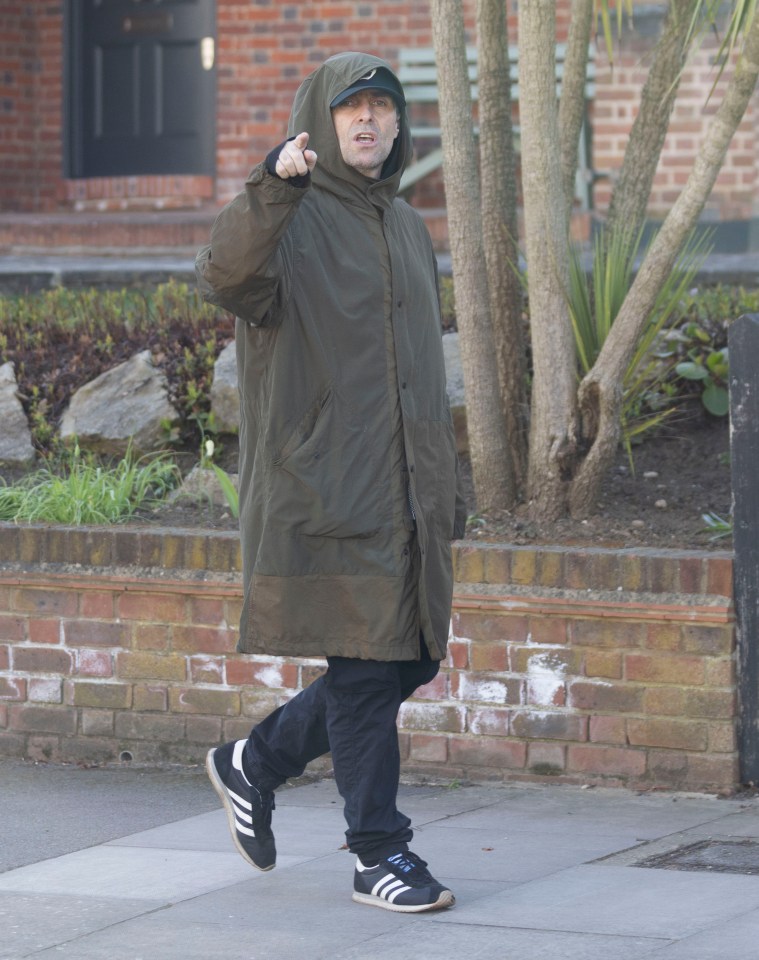 Liam Gallagher walking down a street.