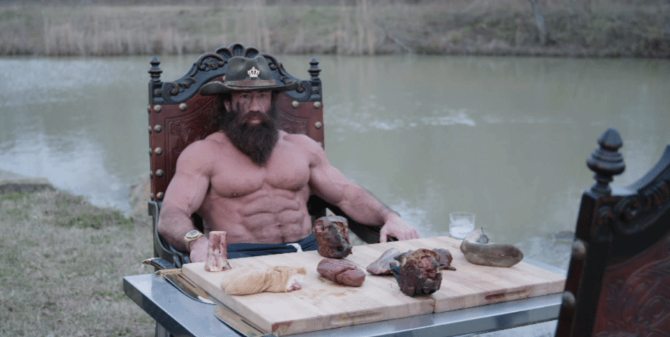 Brian Johnson, known online as the Liver King, holding a large piece of liver.