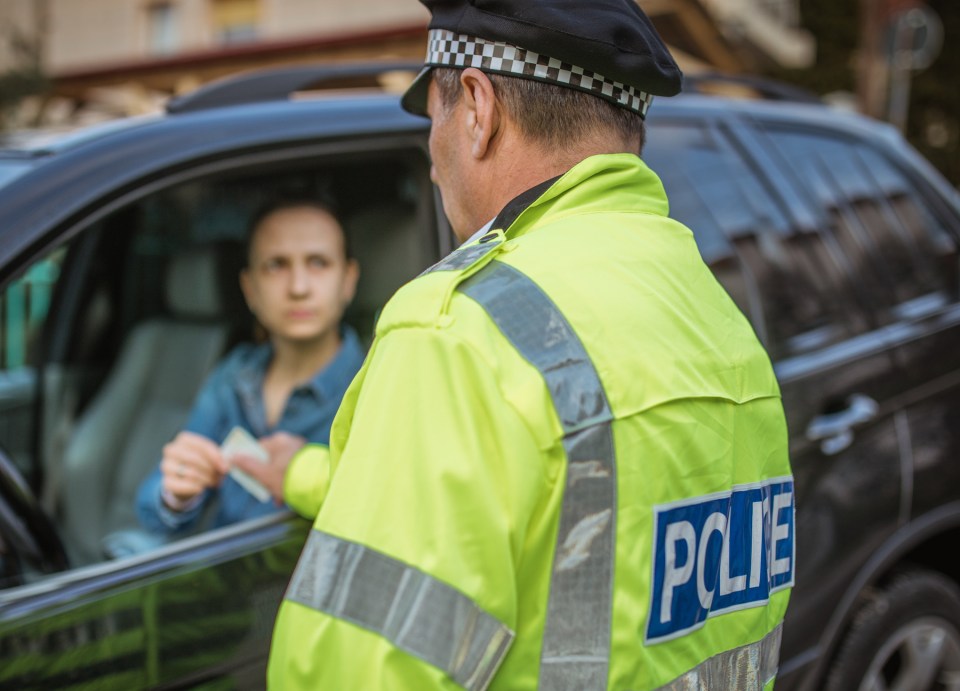 Police officer issuing a traffic ticket to a woman.