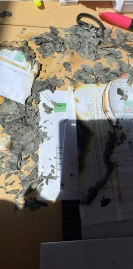 Burned papers and documents on a table.
