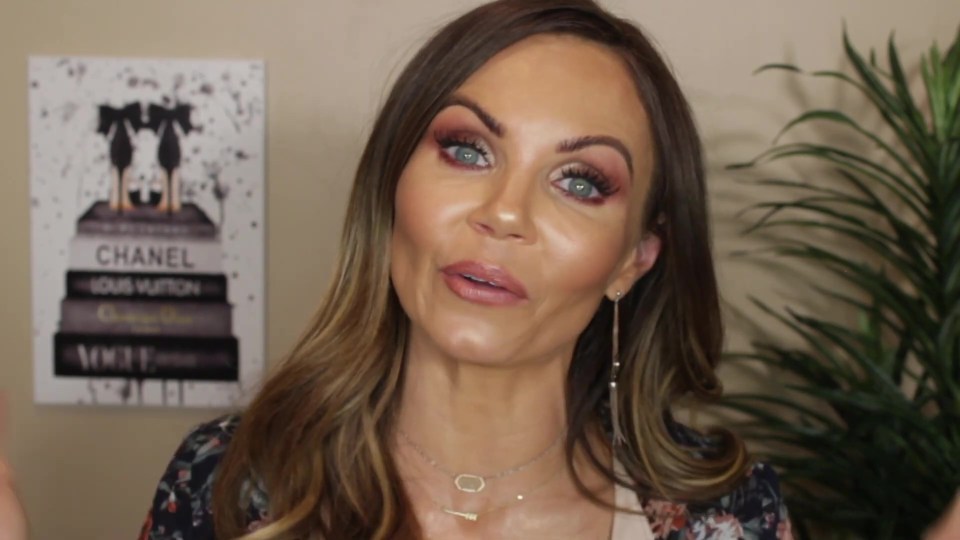 Woman with long brown hair and makeup speaking to the camera.
