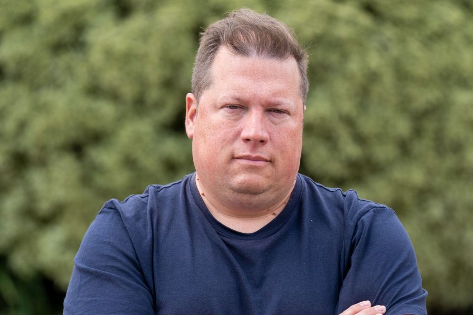 An image collage containing 1 images, Image 1 shows Man with arms crossed looking at the camera
