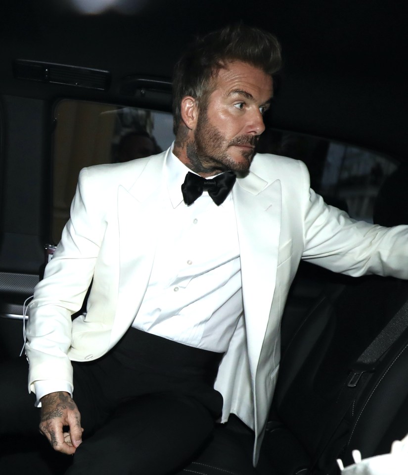 David Beckham in a white tuxedo jacket and black bow tie, sitting in a car.