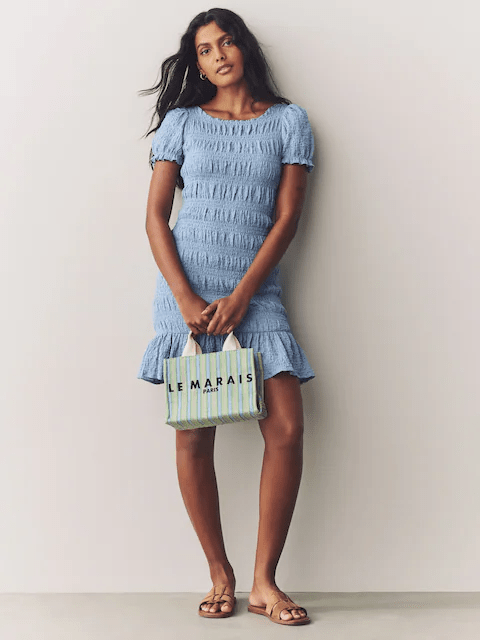 Model wearing a pastel blue shirred puff sleeve mini dress.