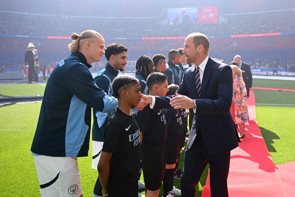 Prince William shaking hands with Erling Haaland and young footballers.