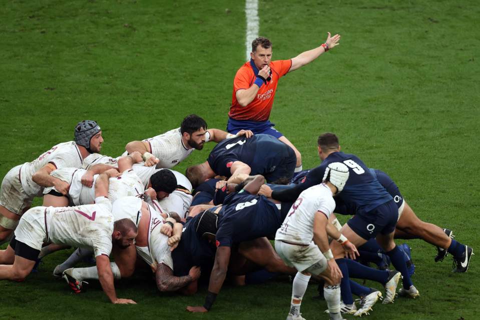 Referee signaling a penalty during a rugby match.