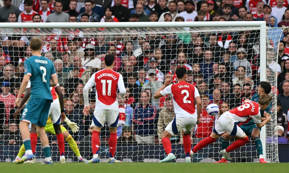 A soccer player scoring a goal in front of a crowd.