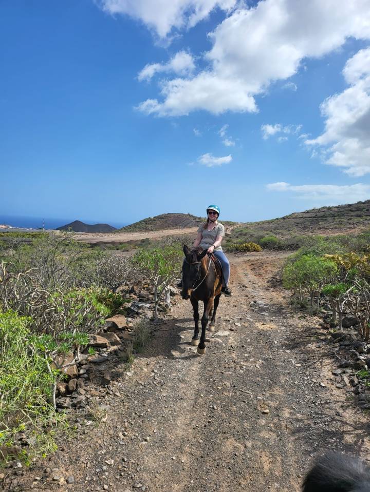 Woman horseback riding on a trail in Tenerife.