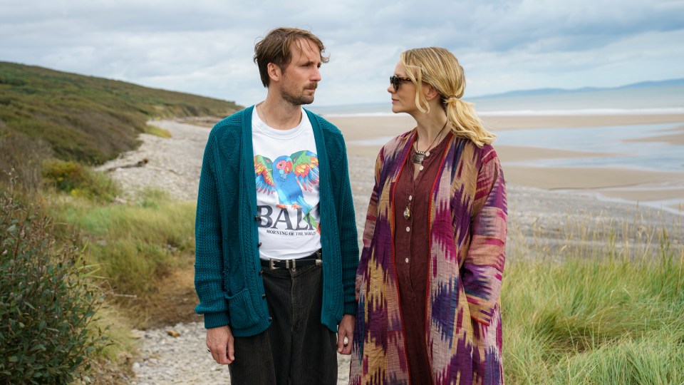 Film still of Tom Basden and Carey Mulligan on a beach.