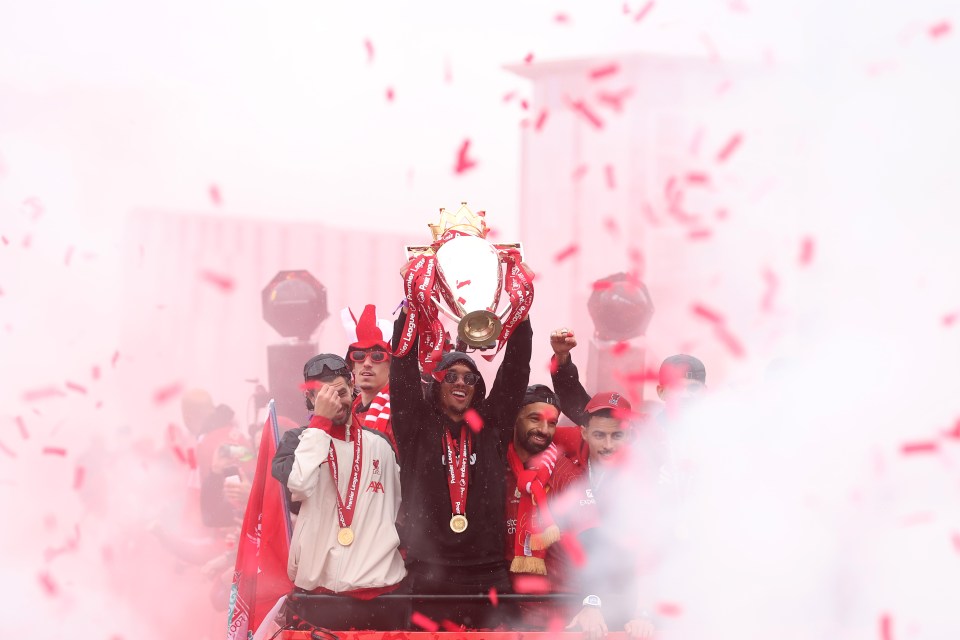 Trent Alexander-Arnold of Liverpool lifts the Premier League trophy during a parade.