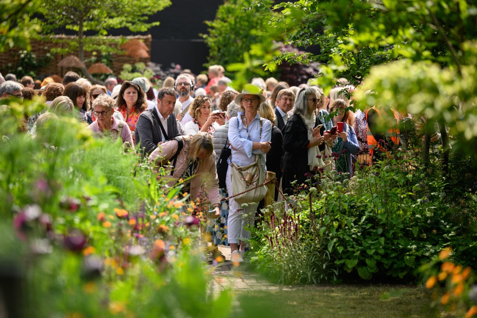Visitors viewing a garden at a flower show.