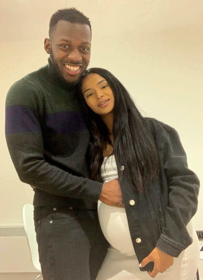 Portrait of a pregnant woman and man embracing.