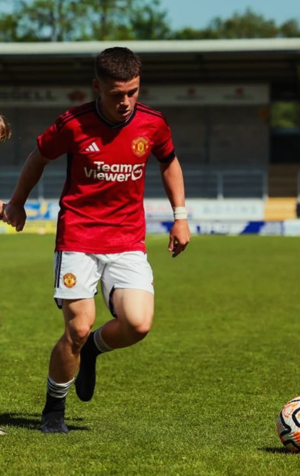 Soccer player in Manchester United uniform running on the field.