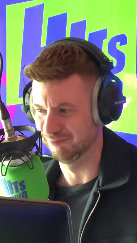 Man with headphones speaking into a microphone.