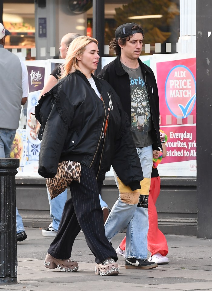 Billie Piper, Johnny Lloyd, and their daughter walking down the street.
