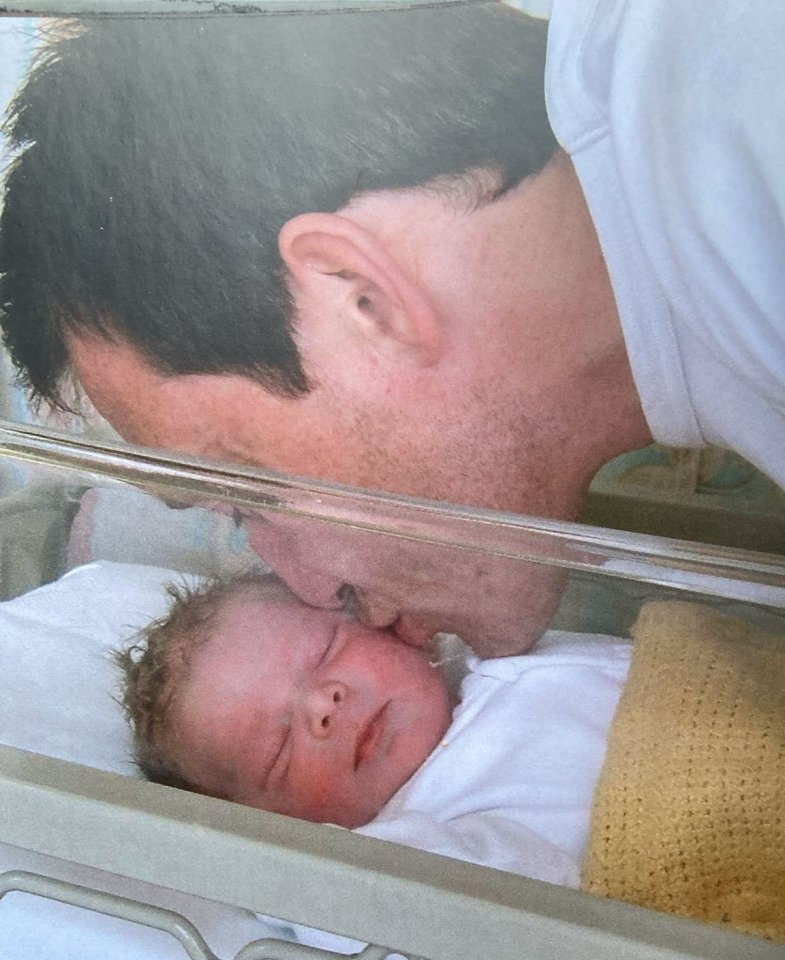 Photo of a father kissing his newborn baby.