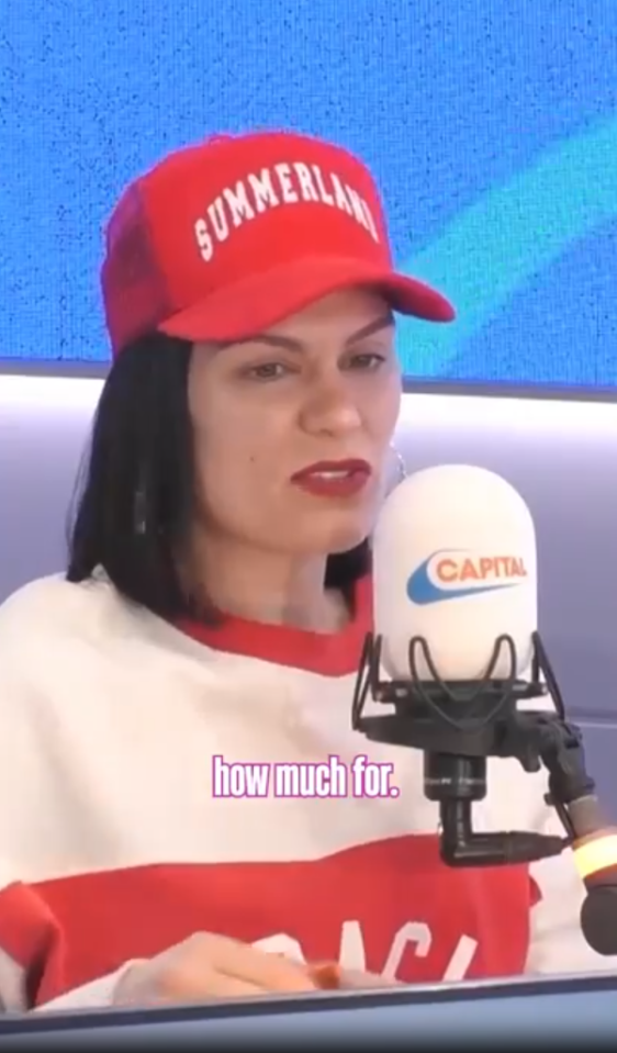 Woman in red hat speaking into Capital radio microphone.