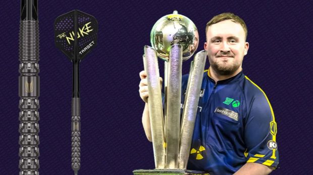 Luke Humphries holding a trophy and his darts.