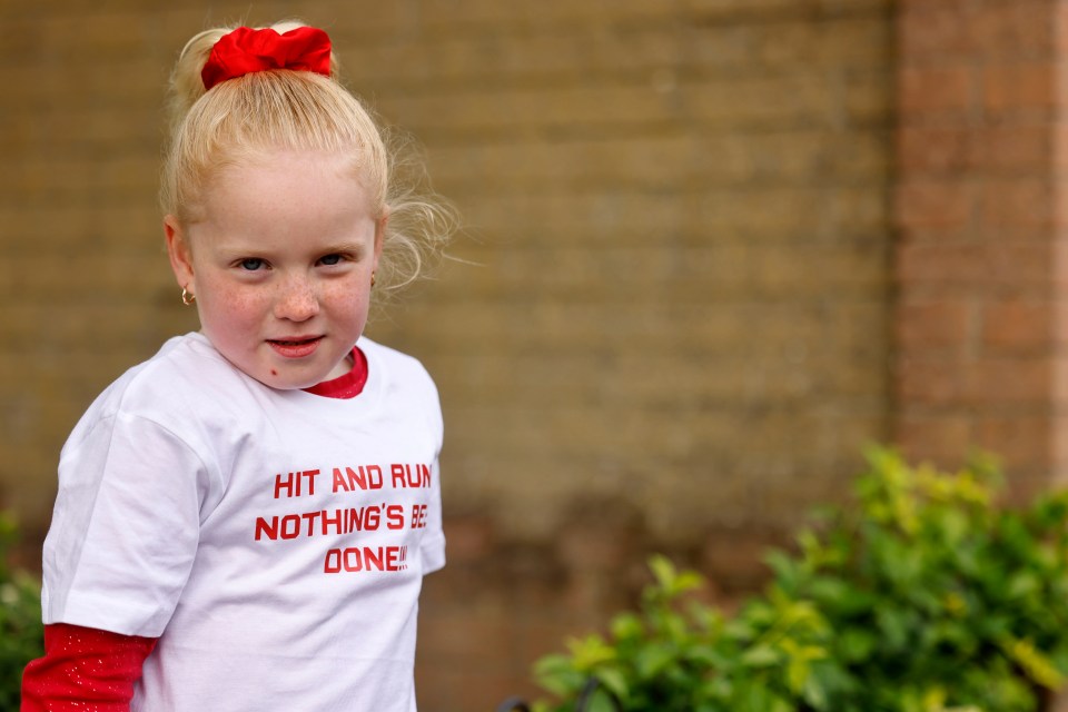 Girl wearing a shirt that says "Hit and Run Nothing's Been Done" protesting a hit and run accident.