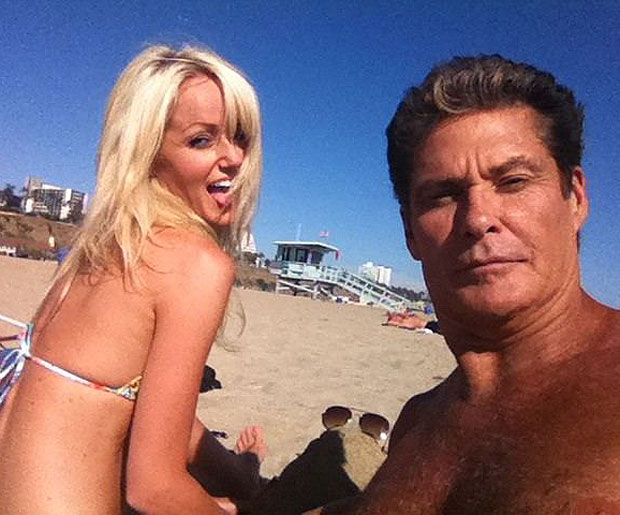 David Hasselhoffs takes pictures of himself & girlfriend Hayley Roberts relaxing in the sun on a beach in the US.