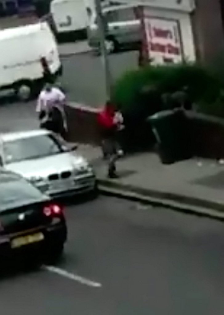 The man in the red top suddenly grabs the pet pooch and slowly begins running away